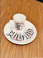 Snack plate showing a fan of playing cards design with a mug featuring the King of Hearts card.