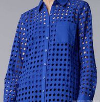 Blue women's button-up shirt with circular cutout perforated design and chest pocket worn by model.