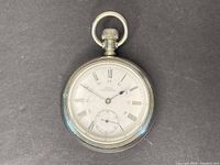 Front view of the antique Regina pocket watch showing the white dial with black Roman numerals, small seconds subdial and key ring loop.