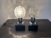 Pair of Kamenicky Senov Brutalist table lamps lit up illustrating the textured glass shades and light patterns