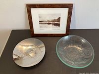 Frontal view of the two bowls and framed photo on a black surface.