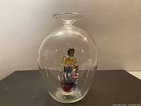 Front view of the clear glass vase showing the blown-in mermaid figurine inside, positioned centrally with visible coloration of the mermaid.