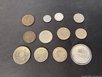 Overview of nine assorted coins of various metals and designs.