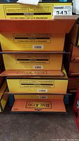 Stack of five yellow/orange RailKing RealTrax switch boxes.