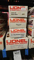 Stacked boxes showing four Lionel train models with labels including Southern Bay Window Caboose 6-9273, Ontario Northland Covered Hopper 66100, N.P. Bay Window Caboose 6-9268, Delaware & Hudson U36C Diesel 6-8050