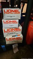 Stack of four Lionel original boxes showing model names and numbers: Delaware & Hudson Bay Window Caboose 9355, Denver Mint Car 7515, Erie Lackawanna GP9 nonpowered dummy unit 8760, Erie Lackawanna GP9 8759.
