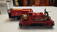 Front and side view of Lionel Fire Car 52 with Pennsylvania Railroad Tie-Jector visible behind