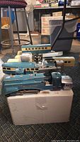 Overview of multiple teal locomotive and car shells with assorted parts on cardboard box