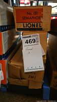 Stacked boxes of Lionel Electric Trains showing labels for No. 151 Semaphore, Canadian Pacific 2321, and related items.