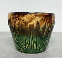 Front view of the Roseville planter showing the embossed sunburst and moon/star motifs with brown to green glaze gradient.