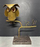 Front view of gold-tone brutalist metal owl sculpture with one missing eye on marble base