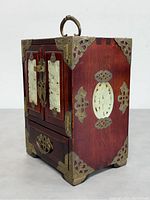 Three-quarter angle showing right side with jade inlay, brass hardware, and handle on top