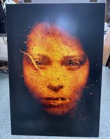 Front image of the metal print showing the abstract fiery orange face on black background.