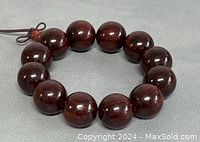 Single view of rosewood bead bracelet showing polished surface and bead size.