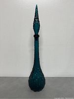 Full-height front view of decanter with stopper against white background