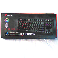 Sealed retail box showing product image, model GK-979, blue mechanical switch, rainbow backlight and Xtrike Me branding.