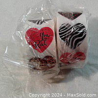 Two rolls of heart stickers with black and white zebra prints, leopard prints, and red hearts with text You Rock, wrapped in clear plastic.