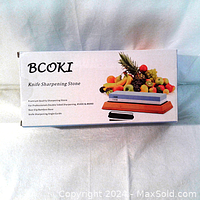 Box of BCOKI Premium Sharpening Stone featuring dual 1000/6000 grit sides, bamboo base and angle guide branding and information.