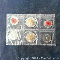 Sealed 2015 Remembrance Day coin set showing 6 coins in plastic packaging. Two quarters with painted poppies and two toonies visible.