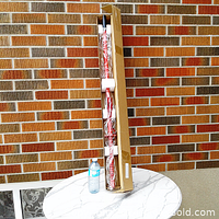 Samurai sword standing in boxed cardboard packaging with a water bottle for scale.