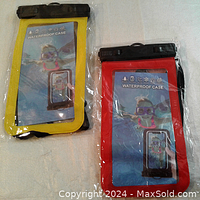 Two waterproof phone cases, one with a yellow border and one with a red border, both sealed in packaging and laid flat on a surface.