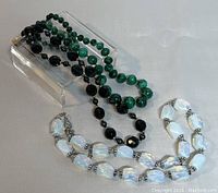 Three vintage necklaces displayed with varying bead colors and sizes on a white background