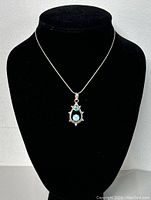 Necklace displayed on black bust showing overall shape and pendant design