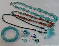 Photo showing the full collection of turquoise jewelry, including necklaces, a bracelet, and multiple pairs of earrings.