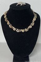 CORO gold-tone necklace and Monet turtle brooch displayed on black bust stand
