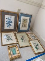 All seven framed art pieces arranged on the floor showing size variations and frame styles