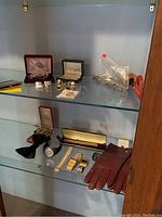 Shelves showing jewelry such as rings, cuff links, watches, gloves and other accessories.