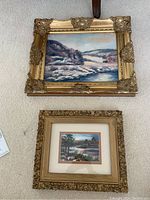 Both framed paintings on carpet showing two pieces in lot