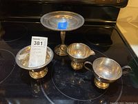 Four footed sterling silver pieces: two pedestal bowls and two handled cups (cream and sugar)
