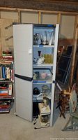 Full front view showing open cabinet with contents including glassware on shelves and kitchen appliances at bottom