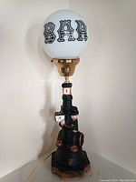 Photo of the vintage Charlie Chaplin bar lamp with black cast ceramic base and white globe marked 'BAR'.