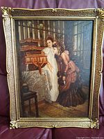 Full view of the oil painting showing two women in Victorian dress observing a wooden music stand or instrument, framed in an elaborate gold frame.