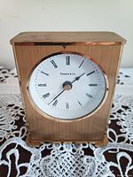 Front view of the Tiffany & Co. desk clock showing the clock face with Roman numerals and the gold-tone rectangular case.