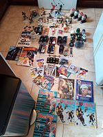 Overview shot showing the assortment of vintage hockey toys, player figurines, trading cards, yearbooks, magazines, and memorabilia laid out on the floor.