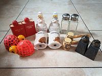 Group photo showing all vintage salt and pepper shakers and related items including turtles, praying lady figurines, spice of life shakers, corncob smoking pipes, pewter and glass shakers.