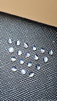 19 natural white moonstone round cabochons with visible cat's eye effect, arranged on textured dark surface.
