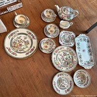 Top view of 19 Aynsley and 4 Coalport china pieces including plates, cups, saucers, teapot, pitcher, and trays all with floral designs and gold trim.