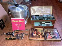 Image showing metal ice bucket, boxed cocktail spoon set, book 'Pass Out,' corkscrews, coasters, and label chains.