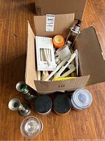 Photo showing the full box with candles inside, plus pewter and glass candleholders in front of the box.