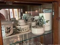 Villeroy & Boch Botanica series items arranged in a cabinet showing multiple pieces with detailed floral illustrations.