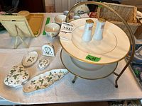 Photo showing two-tier metal plate stand with two Wedgwood California dinner plates, ceramic salt and pepper shakers, Wild Strawberry trinket dishes, and small clock.