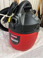 Front angle view showing Craftsman Clean 'n Carry logo, red body, black top housing with carry handle, and attached power cord.