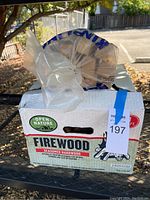 Box of Open Nature Firewood with a sealed bag of firewood on top.