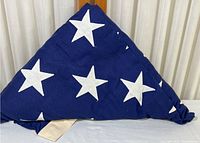 Triangular folded USA flag showing the star section in detail, with crisp folding and visible embroidery.
