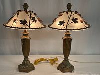 Two matching metal vintage table lamps shown side by side with frosted glass shades and bronze-tone bases
