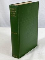 Full view of the green hardcover book standing upright showing front cover and spine with gold lettering and embossed publisher's mark.